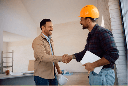 Two men shaking hands, one wearing a safety helmet.